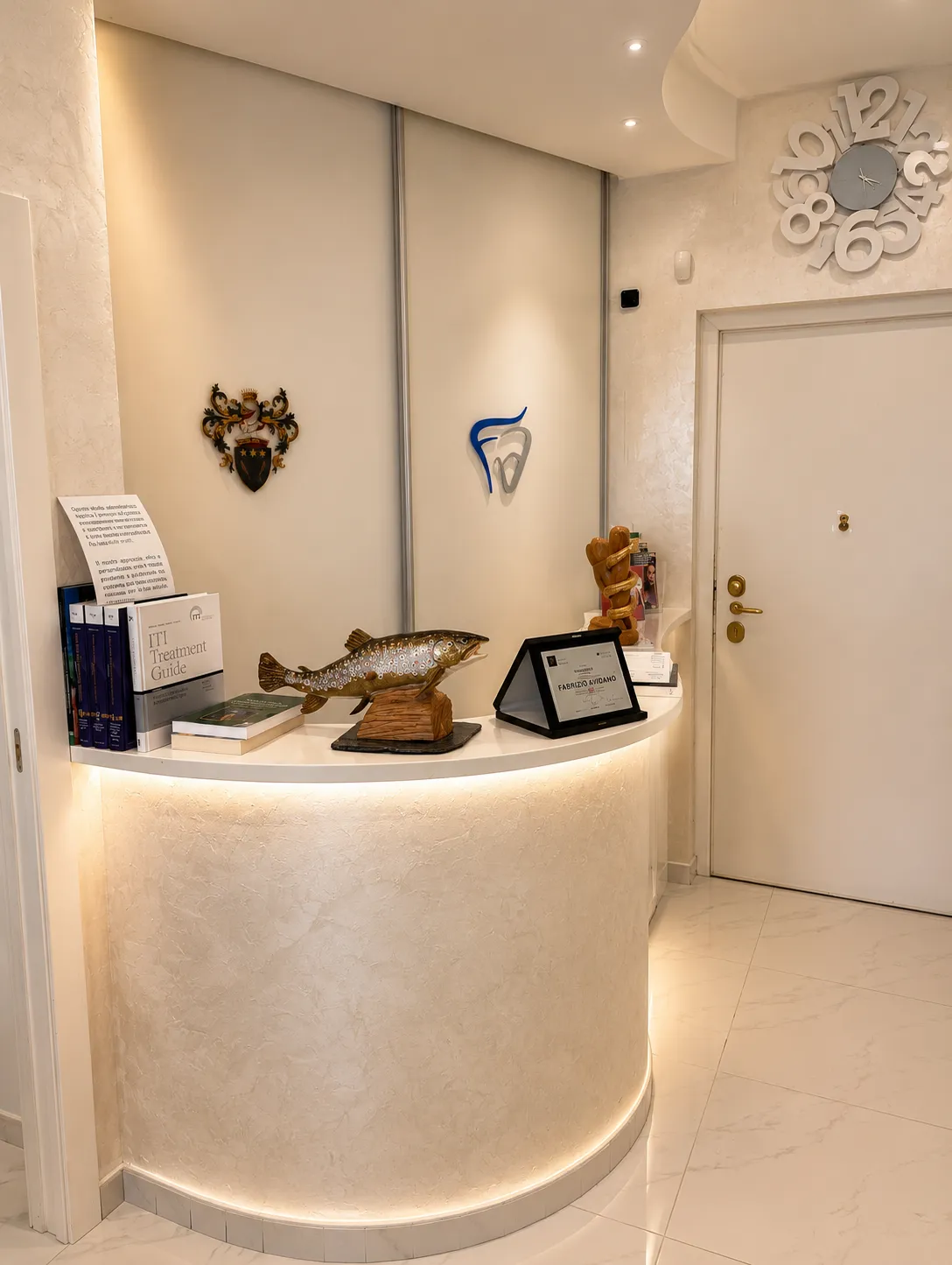 Reception della sede di Milano con banco di accoglienza illuminato.